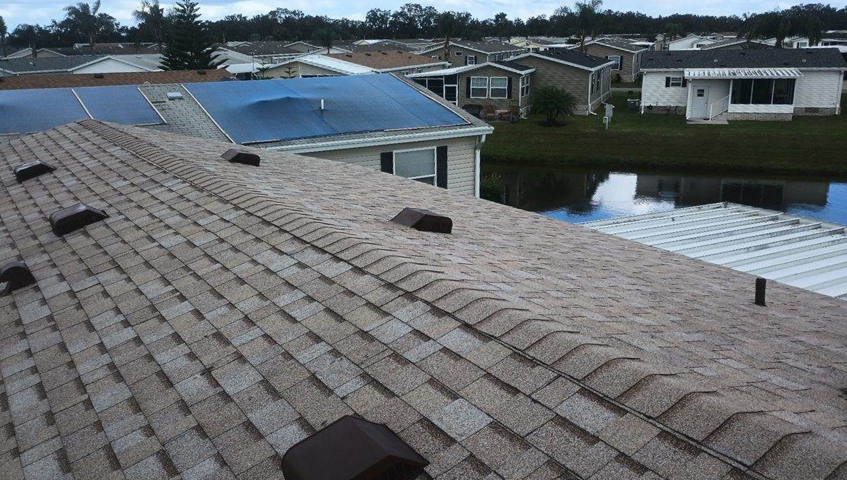 A dark shingle roof with dark brown roof vents.